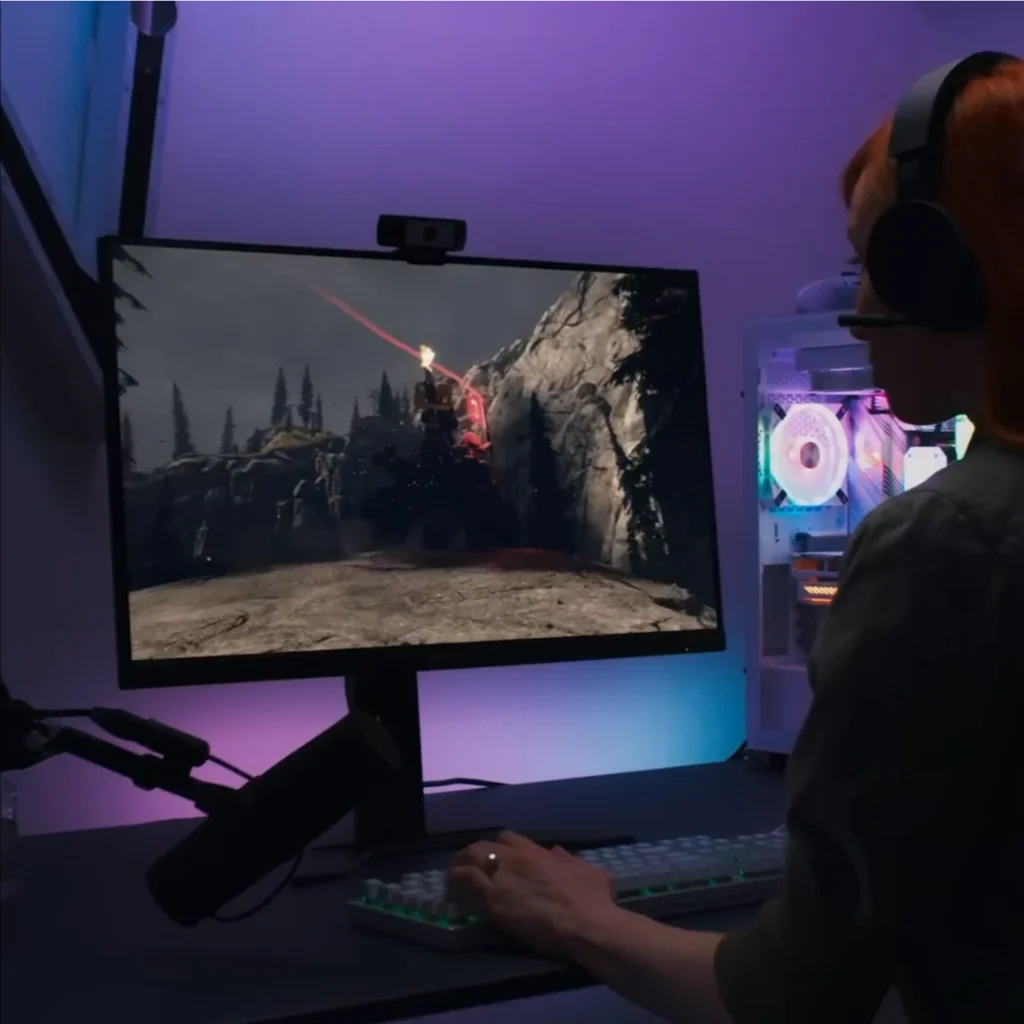 Frau spielt Shooter am Gaming-PC mit RGB-Beleuchtung und Headset