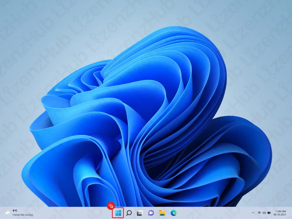 Ein Windows-11-Desktop, in dessen Taskleiste unten das Start-Symbol rot markiert ist. Im Hintergrund ist ein blaues abstraktes Wallpaper zu sehen. Die Uhrzeit zeigt 14:39.