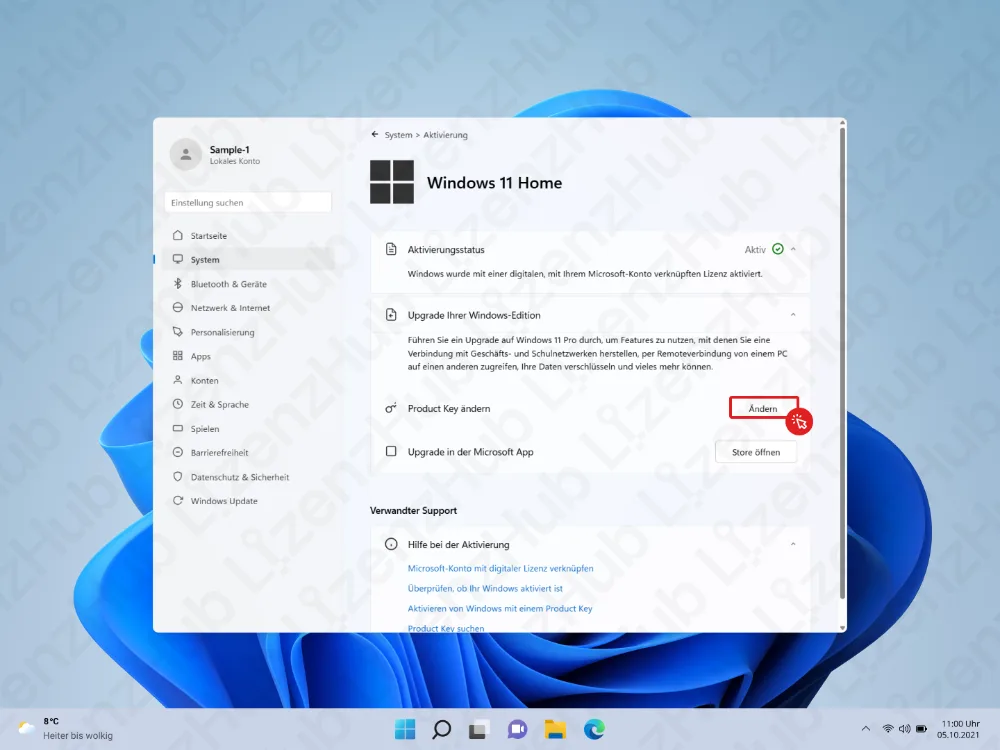 Ein Aktivierungsfenster von Windows 11 Home zeigt Upgrade-Optionen, darunter eine hervorgehobene Schaltfläche Ändern unter Product Key ändern. Im Hintergrund sind ein blaues abstraktes Wallpaper und unten die Taskleiste sichtbar.