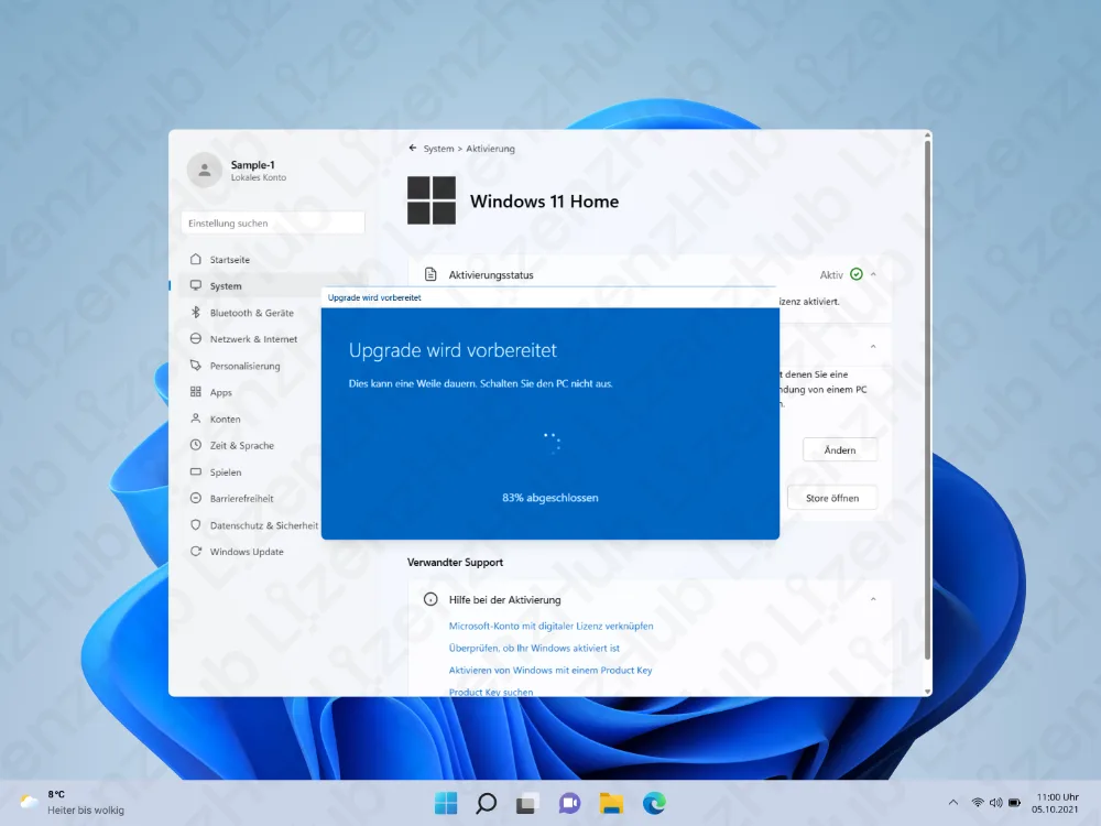 Ein Windows-11-Home-Desktop zeigt ein Einstellungsfenster mit einem blauen Pop-up: Upgrade wird vorbereitet, 87% abgeschlossen. Im Hintergrund sind das Windows-Standard-Wallpaper und unten die Taskleiste sichtbar.