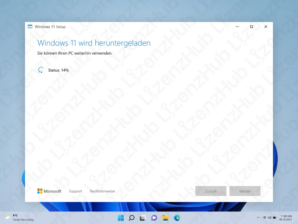 Ein Setup-Fenster zeigt Windows 11 wird heruntergeladen mit einem kreisförmigen Fortschrittsindikator bei 14%. Im Hintergrund sind Teile des Desktops und der Taskleiste zu sehen.